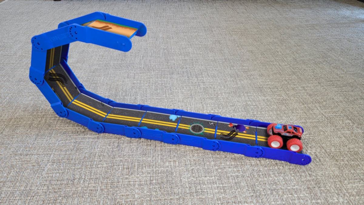 Bright blue Redi-Rampz street track curved into a hairpin shape with a red monster truck