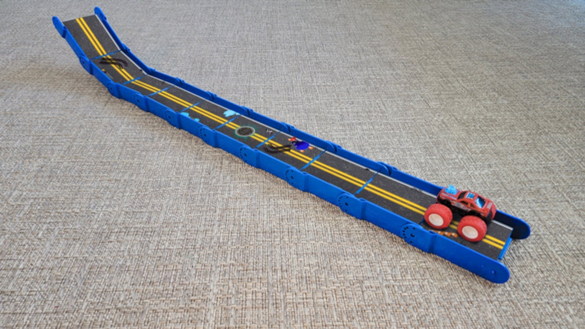 Bright blue Redi-Rampz street ramp built as a long incline with a red monster truck at the bottom