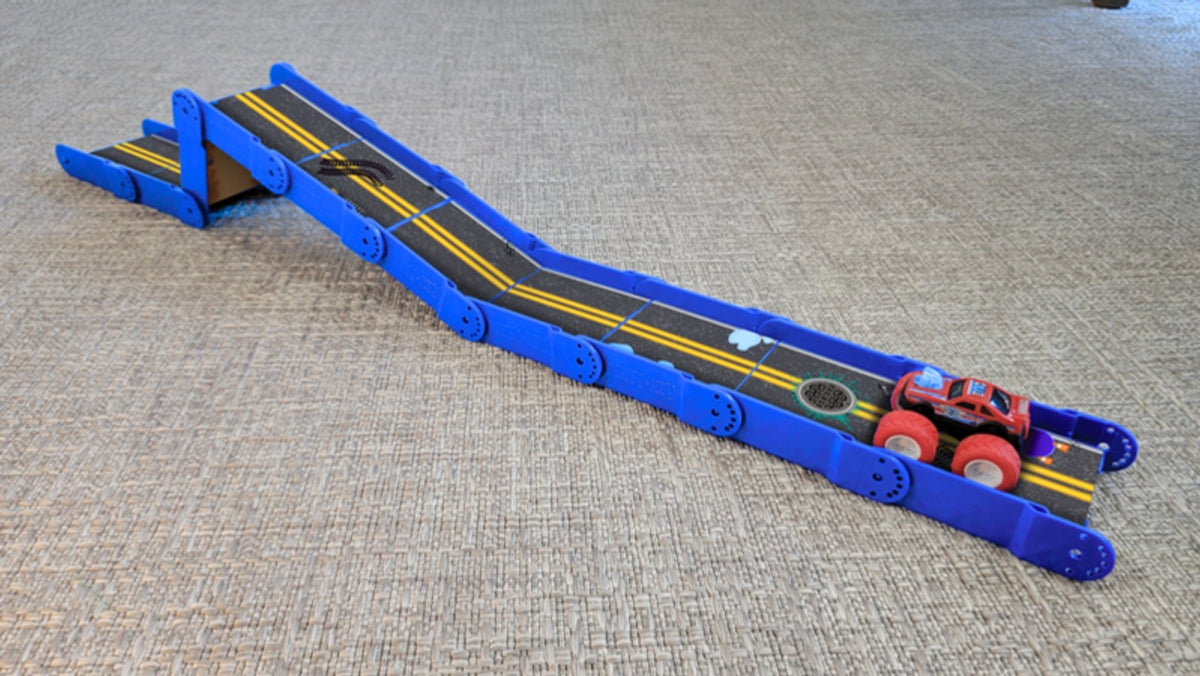 Bright blue Redi-Rampz street ramp with a raised step and a red monster truck at the bottom